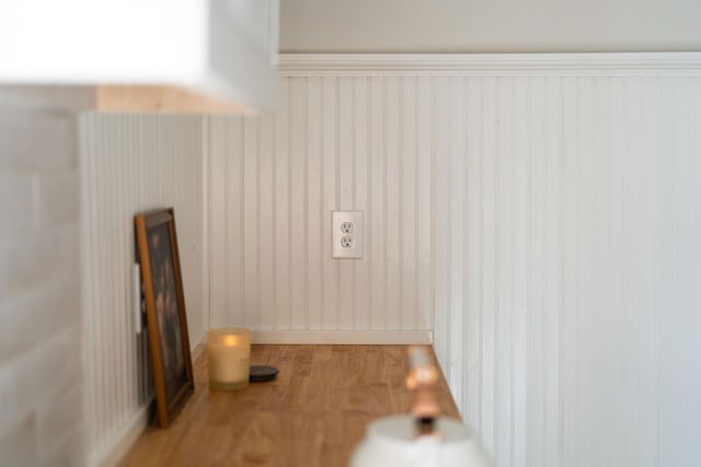 laundry room with baseboards and wood finished floors
