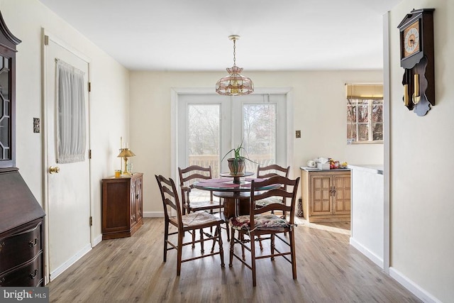  - dining room with light wood-style floors, baseboards, and a chandelier