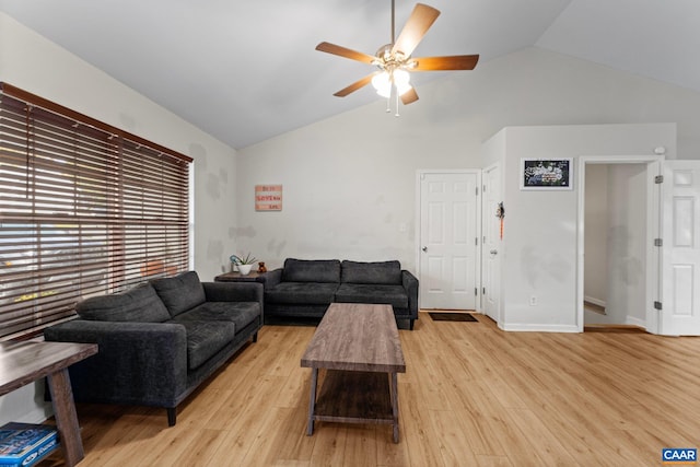 living room featuring lofted ceiling, light wood-style floors, a ceiling fan, and baseboards