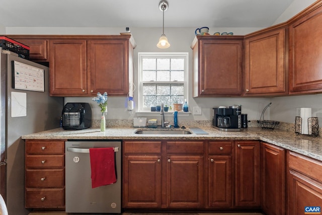 kitchen with hanging light fixtures, a sink, brown cabinetry, dishwasher, and light stone counters