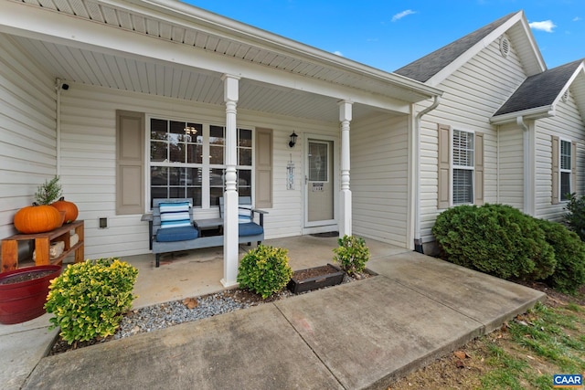 doorway to property with roof with shingles and covered porch