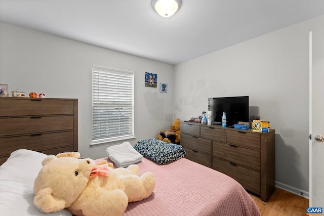 bedroom with light wood-style flooring and baseboards
