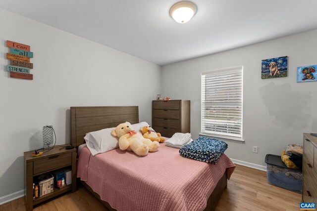 bedroom with baseboards and wood finished floors
