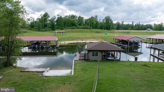 dock area with boat lift, a water view, a yard, and view of wooded area
