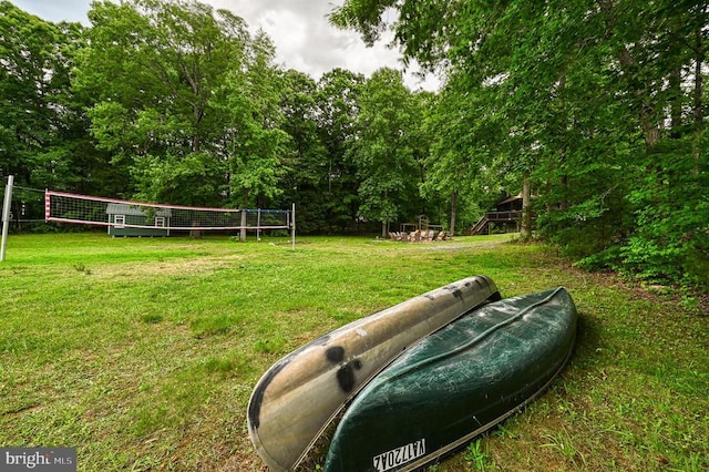 view of property's community with volleyball court and a lawn