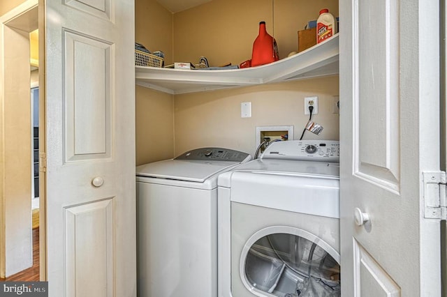 laundry area with washing machine and dryer and wood finished floors