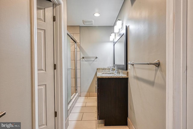 full bath featuring a stall shower, vanity, and tile patterned flooring