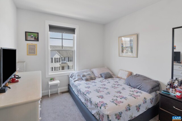 bedroom featuring light carpet and baseboards