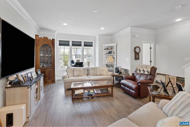 living room featuring light wood finished floors, ornamental molding, and recessed lighting