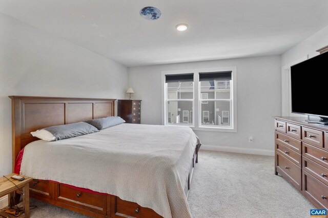 bedroom with light colored carpet and baseboards