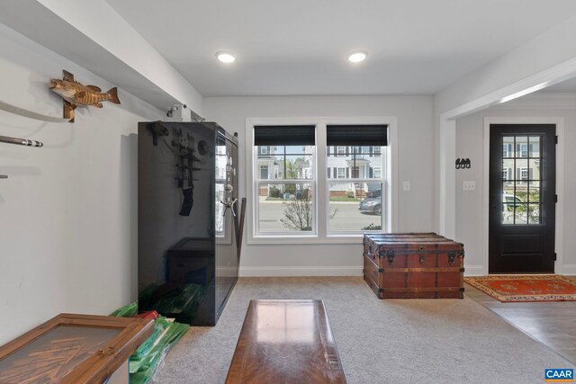 carpeted entrance foyer featuring baseboards and recessed lighting