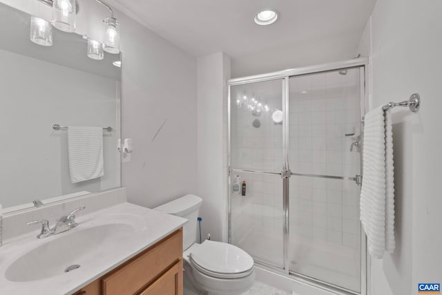 full bathroom featuring a shower stall, toilet, and vanity