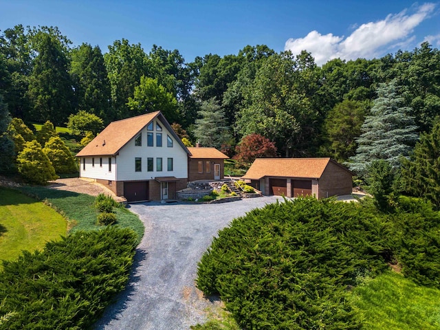 613 Dices Spring Rd, Weyers Cave, VA 24486 - view of front of house featuring brick siding, a wooded view, an outbuilding, and a garage
