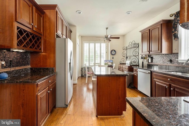 10207 Iverson Ave, Fredericksburg, VA 22407 - kitchen featuring stainless steel appliances, a sink, decorative backsplash, a center island, and dark stone countertops