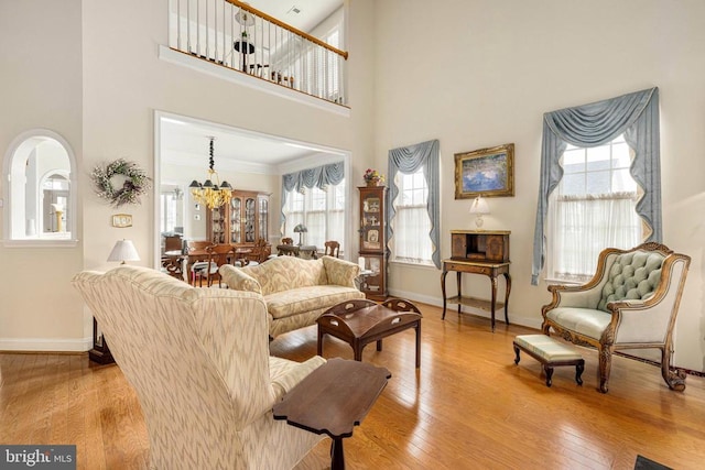 10207 Iverson Ave, Fredericksburg, VA 22407 - living area featuring baseboards, a towering ceiling, wood finished floors, arched walkways, and a chandelier