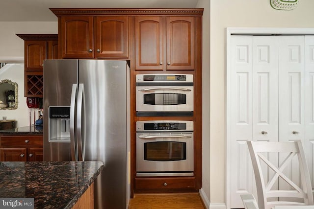 10207 Iverson Ave, Fredericksburg, VA 22407 - kitchen featuring appliances with stainless steel finishes, dark stone counters, wood finished floors, and baseboards