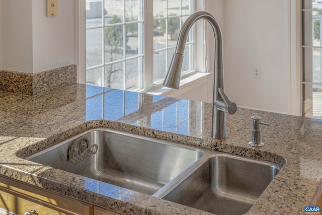 interior details with light stone countertops and a sink