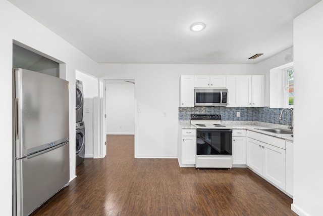 4220 Traveler Rd, Rockingham, VA 22801 - kitchen with stainless steel appliances, a sink, stacked washer and clothes dryer, dark wood-style flooring, and white cabinets
