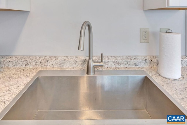 interior details with white cabinets, light countertops, and a sink