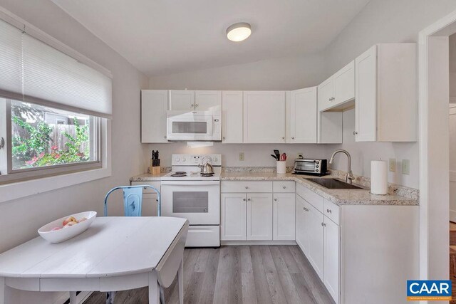 kitchen featuring a sink, lofted ceiling, white appliances, light wood-style flooring, and white cabinets
