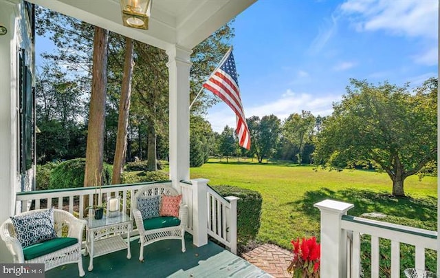  - wooden porch featuring a lawn and view of wooded area