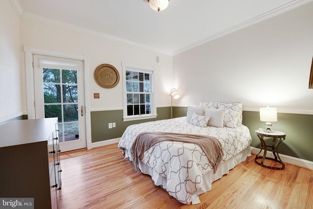  - bedroom with wood finished floors, crown molding, and access to exterior