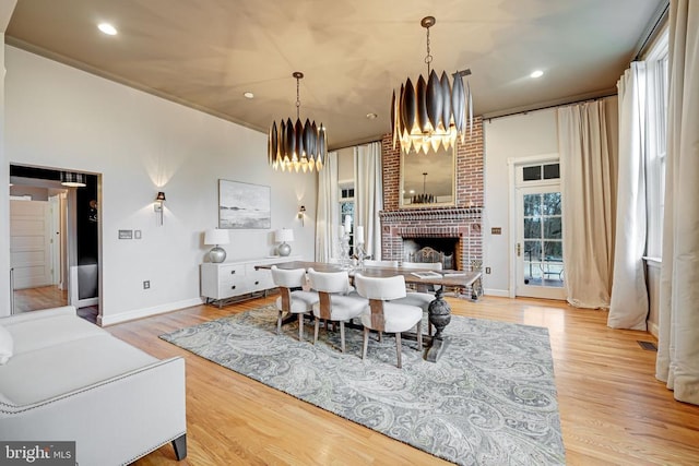  - dining area with a chandelier, a fireplace, wood finished floors, and recessed lighting