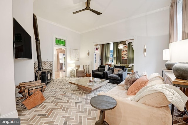  - living area featuring a wood stove, ceiling fan, brick floors, and crown molding