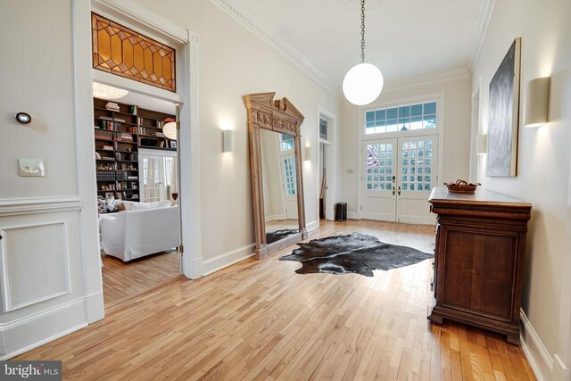  - foyer with french doors, crown molding, and light wood finished floors