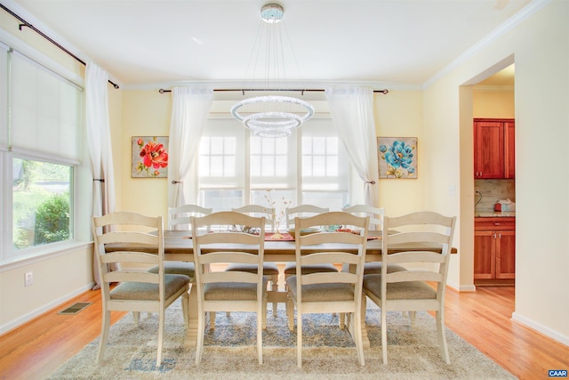 1623 Brandywine Dr, Charlottesville, VA 22901 - dining space with healthy amount of natural light, light wood-type flooring, a chandelier, and crown molding