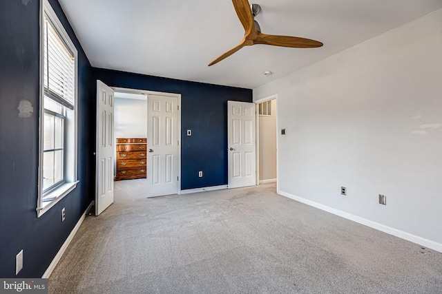 unfurnished bedroom featuring baseboards, light colored carpet, a ceiling fan, and a closet