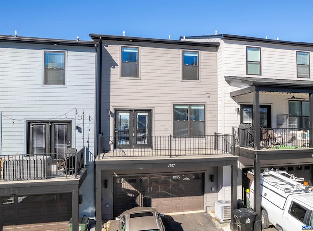 back of house featuring a garage and central AC unit