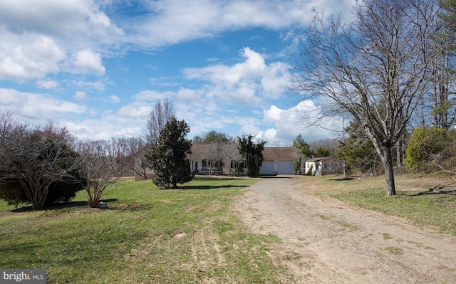  - view of front facade featuring driveway, an attached garage, and a front yard