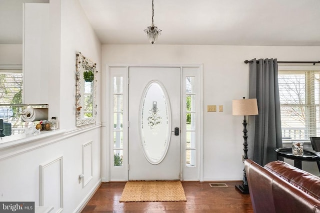 foyer entrance featuring a wealth of natural light and dark wood-style flooring