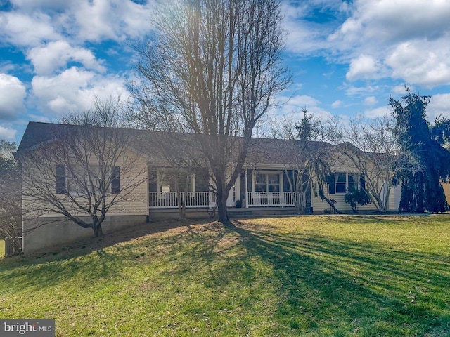 ranch-style house featuring a front yard and covered porch