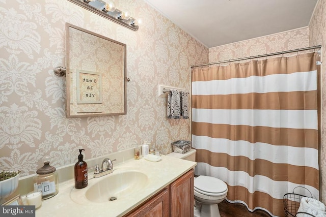 bathroom with toilet, vanity, wallpapered walls, and a shower with shower curtain
