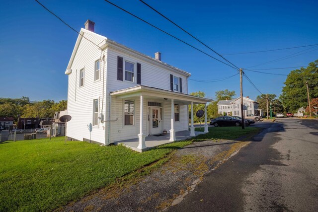 111 S High St, Edinburg, VA 22824 - view of front of property with covered porch, a chimney, and a front lawn
