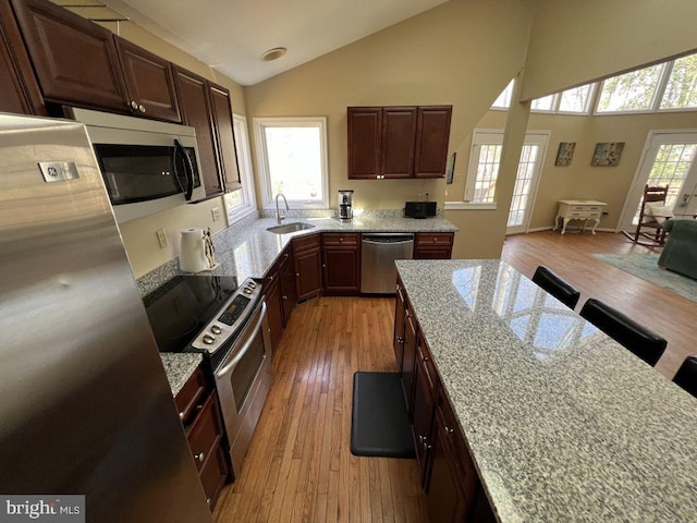 902 Eastover Pkwy, Locust Grove, VA 22508 - kitchen with appliances with stainless steel finishes, a sink, light wood-style flooring, light stone counters, and high vaulted ceiling