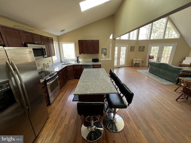 902 Eastover Pkwy, Locust Grove, VA 22508 - kitchen featuring appliances with stainless steel finishes, a sink, french doors, light wood-style flooring, and high vaulted ceiling