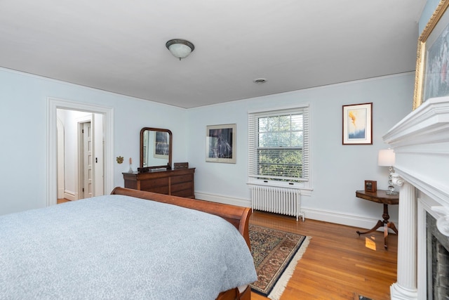 675 Beverley St E, Staunton, VA 24401 - bedroom with radiator, a fireplace, wood finished floors, and baseboards