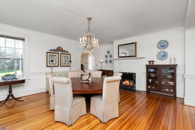675 Beverley St E, Staunton, VA 24401 - dining room with wood-type flooring, arched walkways, a high end fireplace, a chandelier, and wainscoting