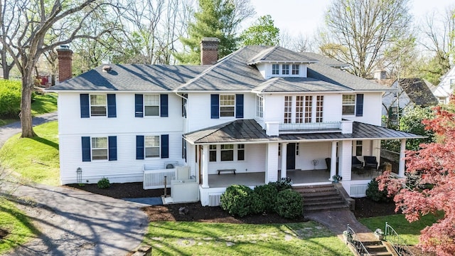 675 Beverley St E, Staunton, VA 24401 - view of front of home featuring a chimney, a standing seam roof, a porch, a front lawn, and metal roof