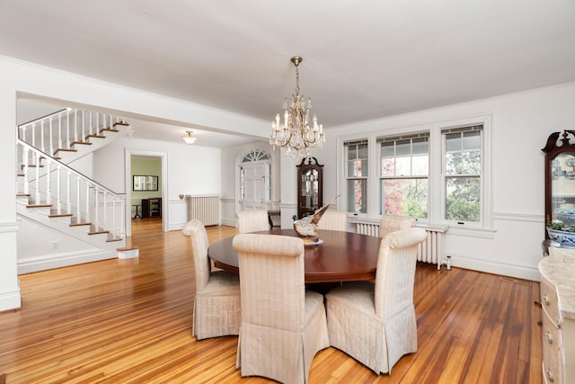 675 Beverley St E, Staunton, VA 24401 - dining area featuring radiator, a chandelier, light wood finished floors, stairs, and crown molding