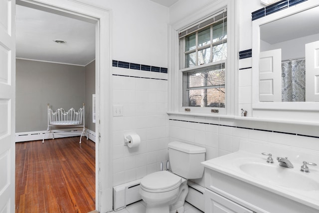 675 Beverley St E, Staunton, VA 24401 - full bath featuring tile walls, a baseboard heating unit, toilet, vanity, and wood finished floors