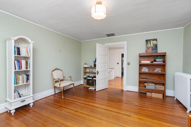 675 Beverley St E, Staunton, VA 24401 - living area with radiator heating unit, light wood-style flooring, ornamental molding, and baseboards