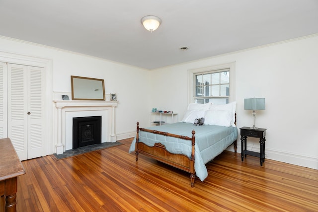 675 Beverley St E, Staunton, VA 24401 - bedroom with crown molding, wood finished floors, a fireplace with flush hearth, a closet, and baseboards