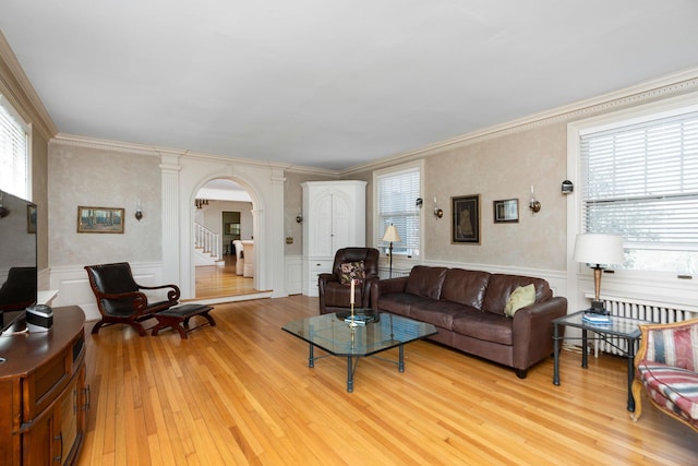 675 Beverley St E, Staunton, VA 24401 - living area with arched walkways, light wood-type flooring, stairway, radiator heating unit, and a decorative wall