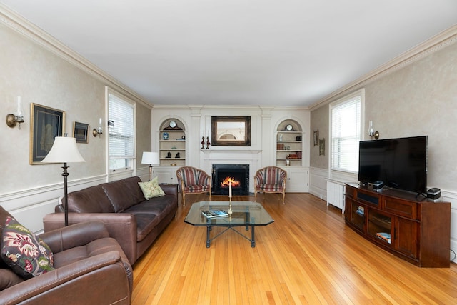 675 Beverley St E, Staunton, VA 24401 - living room with light wood-style flooring, built in features, a fireplace with flush hearth, ornamental molding, and a wainscoted wall