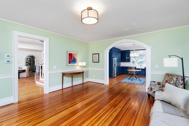 675 Beverley St E, Staunton, VA 24401 - living area with arched walkways, wood-type flooring, crown molding, a chandelier, and baseboards