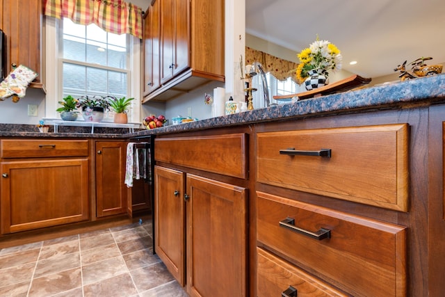 kitchen featuring brown cabinetry and dark stone counters